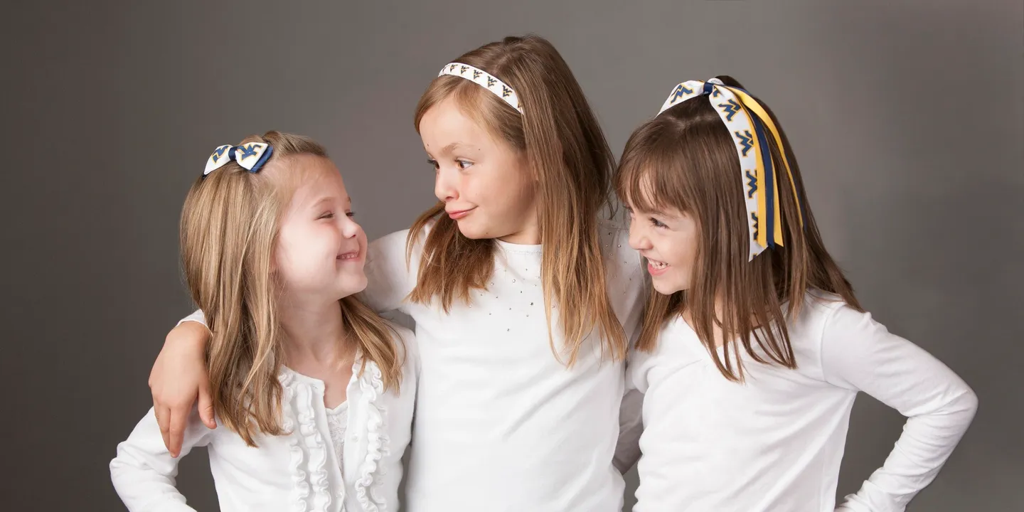 Three little girls are posing for a photo.