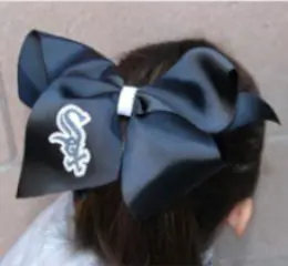 A girl wearing a chicago white sox bow.